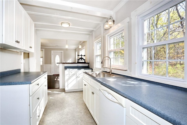 kitchen featuring white dishwasher, crown molding, white cabinetry, and sink