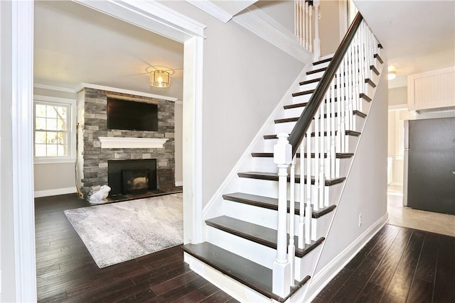 stairs featuring a fireplace, hardwood / wood-style flooring, and ornamental molding