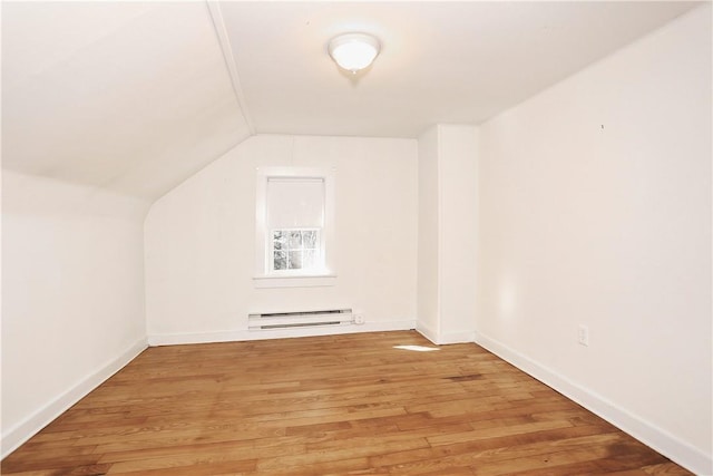 additional living space featuring baseboard heating, wood-type flooring, and lofted ceiling