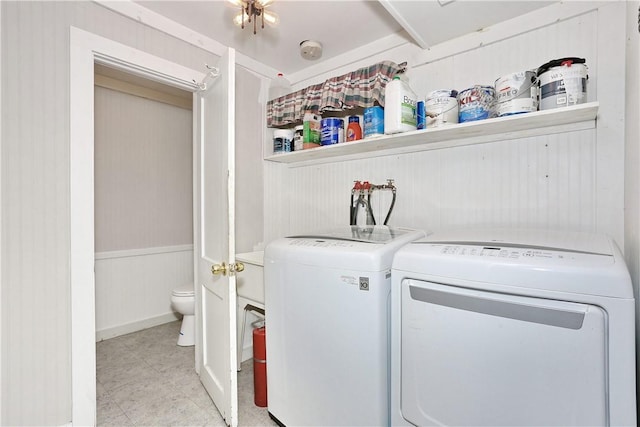 laundry room featuring separate washer and dryer and wood walls