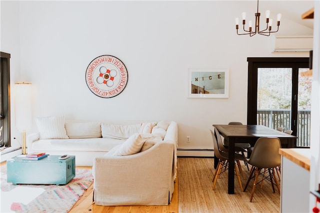 living room featuring a wall unit AC, light hardwood / wood-style flooring, an inviting chandelier, and a baseboard heating unit