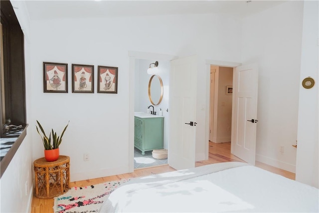 bedroom with light wood-type flooring and sink