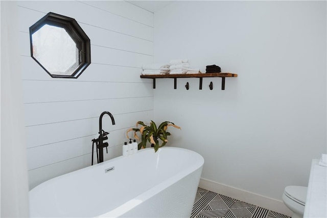 bathroom featuring a bath, toilet, and tile patterned floors