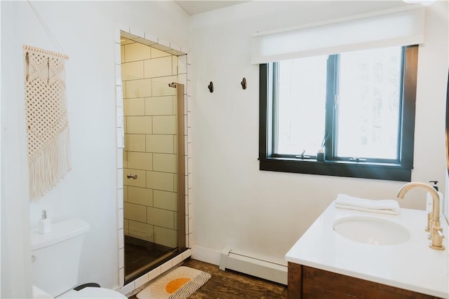 bathroom with baseboard heating, vanity, a shower with shower door, and toilet