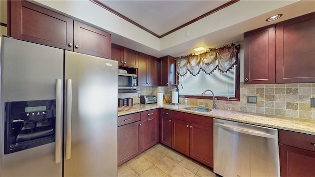 kitchen with appliances with stainless steel finishes, tasteful backsplash, light stone counters, crown molding, and sink