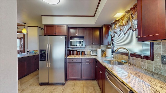 kitchen featuring sink, hanging light fixtures, light stone countertops, tasteful backsplash, and stainless steel appliances