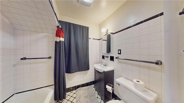 full bathroom with vanity, toilet, tile walls, and shower / tub combo with curtain