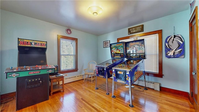 game room featuring wood-type flooring and baseboard heating