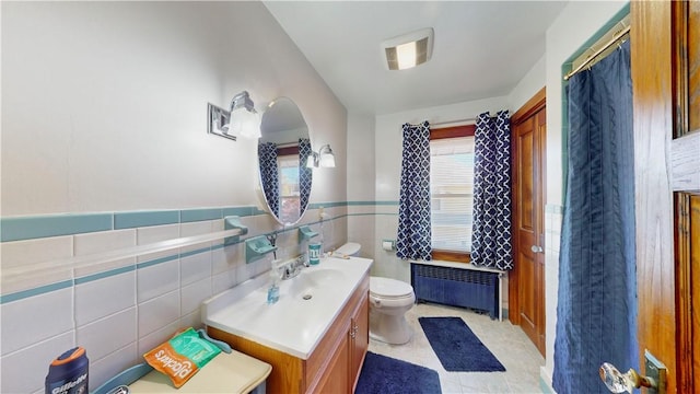 bathroom with vanity, tile patterned floors, toilet, tile walls, and radiator heating unit