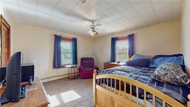 carpeted bedroom with baseboard heating and ceiling fan