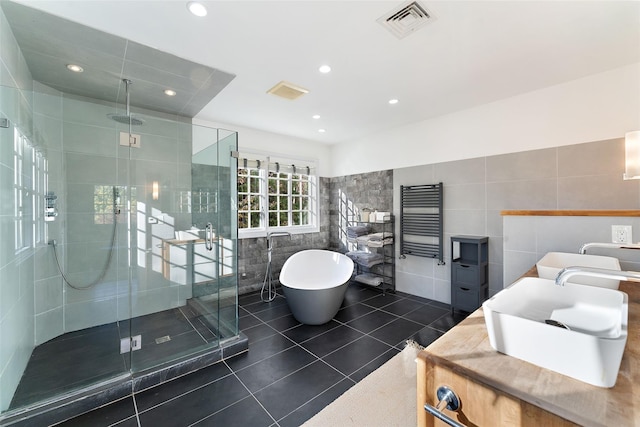 bathroom with tile walls, tile patterned flooring, and independent shower and bath