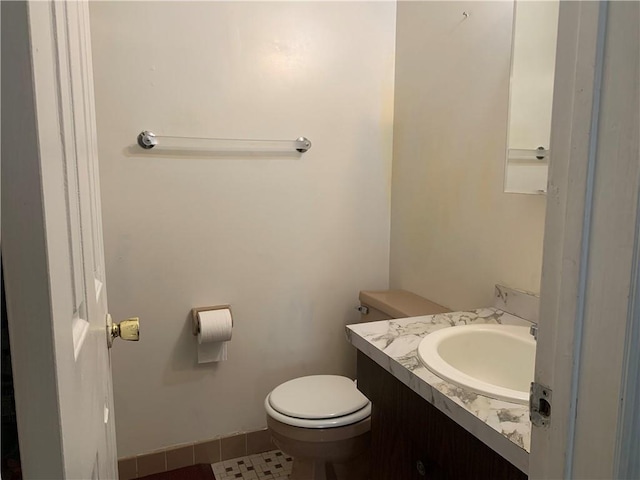 bathroom with tile patterned flooring, vanity, and toilet