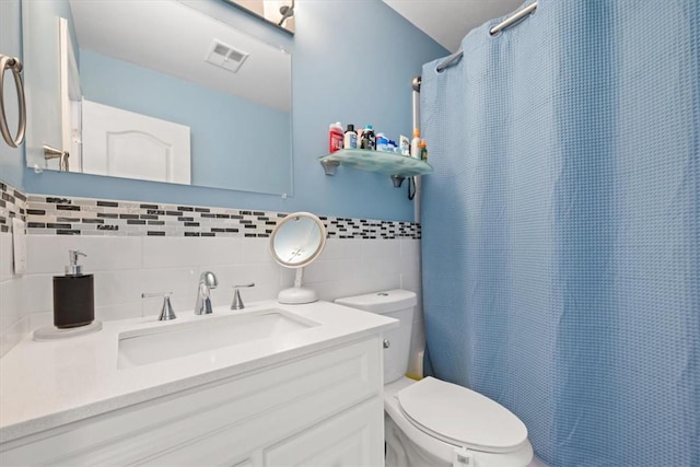 bathroom featuring vanity, tasteful backsplash, toilet, and curtained shower