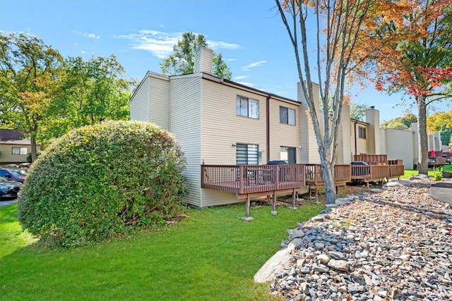 rear view of house featuring a deck and a lawn