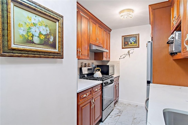 kitchen with appliances with stainless steel finishes and light stone counters