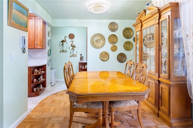 dining room with light parquet flooring and an inviting chandelier