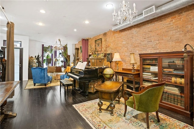 interior space with dark wood-type flooring, brick wall, and a notable chandelier