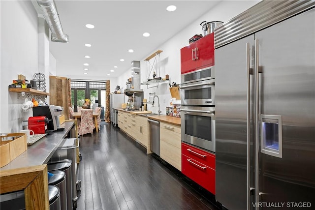 kitchen featuring stainless steel appliances, dark hardwood / wood-style floors, sink, and wooden counters