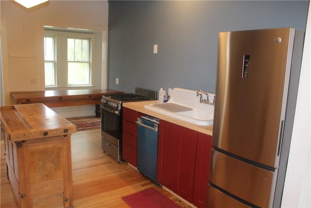 kitchen featuring wooden counters, sink, stainless steel appliances, and light hardwood / wood-style flooring