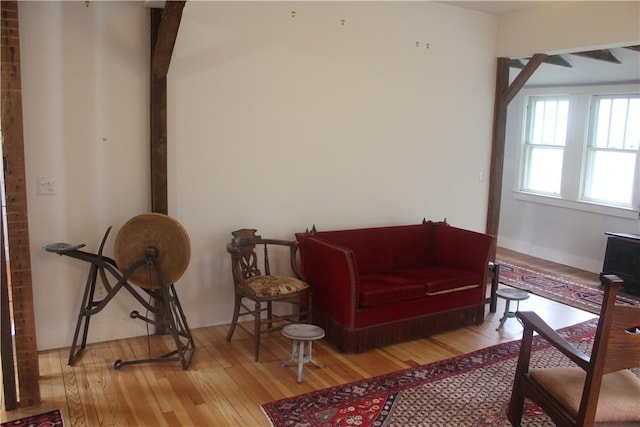 sitting room with beam ceiling and light hardwood / wood-style flooring