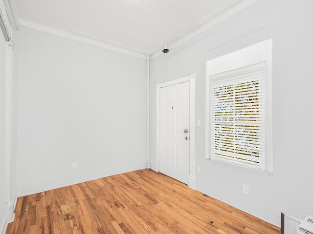 foyer with hardwood / wood-style flooring and crown molding