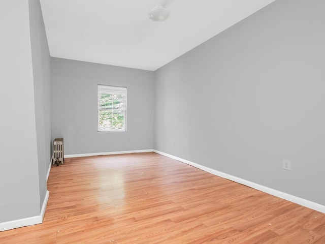 spare room with radiator and light hardwood / wood-style floors