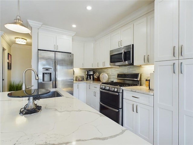 kitchen featuring tasteful backsplash, pendant lighting, white cabinets, and stainless steel appliances