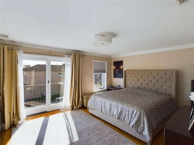 bedroom featuring access to outside, multiple windows, and ornamental molding