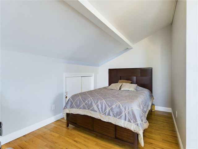 bedroom with hardwood / wood-style flooring and lofted ceiling