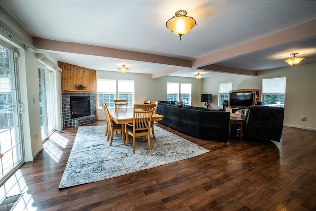 dining area with a fireplace, dark hardwood / wood-style flooring, and beamed ceiling