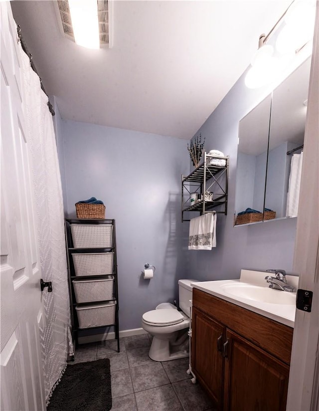 bathroom with tile patterned flooring, vanity, and toilet