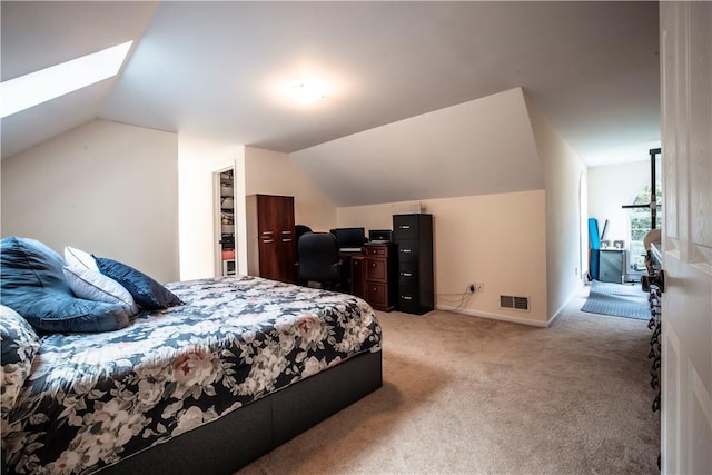 bedroom with a walk in closet, a closet, light colored carpet, and lofted ceiling