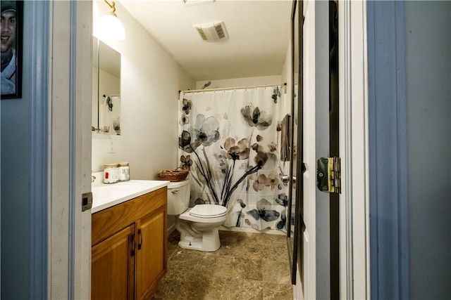 bathroom featuring curtained shower, vanity, and toilet