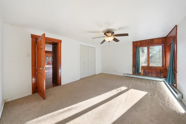 unfurnished bedroom featuring carpet flooring, baseboard heating, and ceiling fan