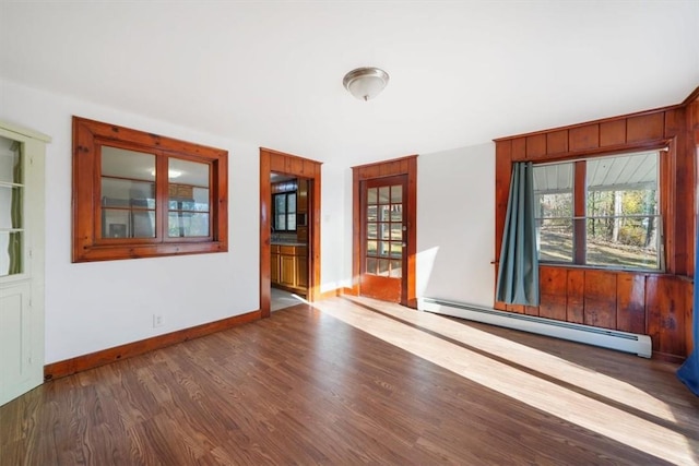 unfurnished room featuring dark wood-type flooring and a baseboard radiator