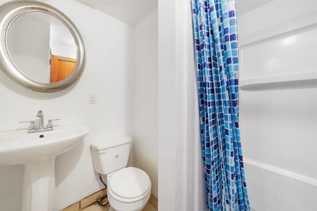 bathroom with tile patterned floors, a shower with curtain, toilet, and sink