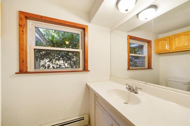 bathroom featuring vanity, a baseboard heating unit, and toilet