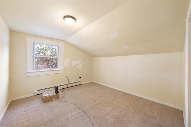 additional living space with light colored carpet, vaulted ceiling, and baseboard heating