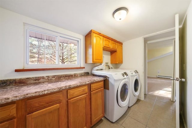 laundry area featuring cabinets, light tile patterned floors, washing machine and dryer, and a baseboard radiator