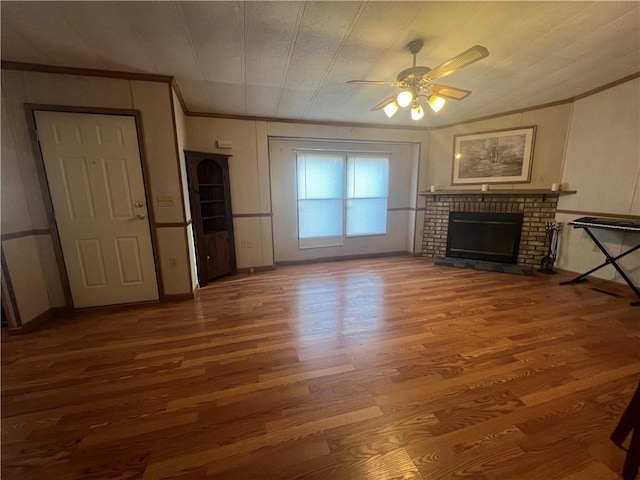 unfurnished living room featuring hardwood / wood-style floors, a brick fireplace, and ceiling fan