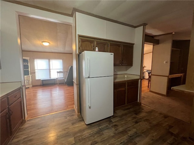 kitchen with white refrigerator, dark hardwood / wood-style flooring, lofted ceiling, and dark brown cabinetry