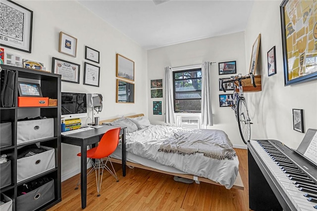 bedroom with cooling unit and wood-type flooring