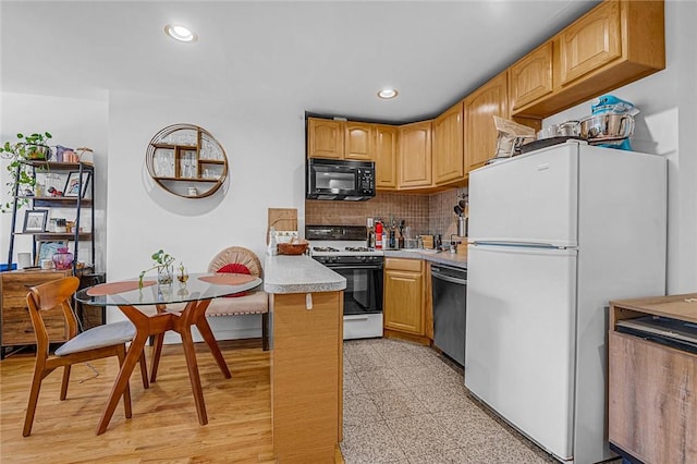 kitchen featuring kitchen peninsula, white appliances, and backsplash