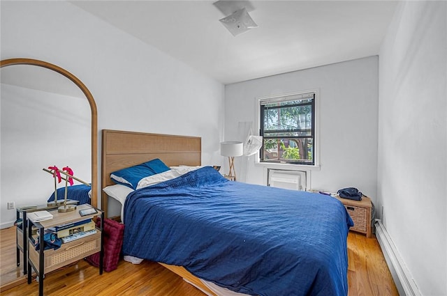 bedroom featuring hardwood / wood-style flooring and a baseboard radiator