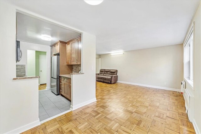 kitchen with backsplash, light parquet flooring, stainless steel appliances, and a wall unit AC