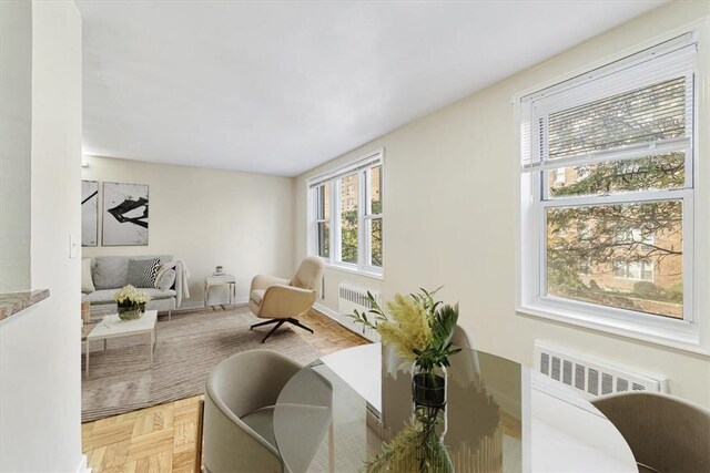 sitting room featuring light parquet floors, plenty of natural light, and radiator