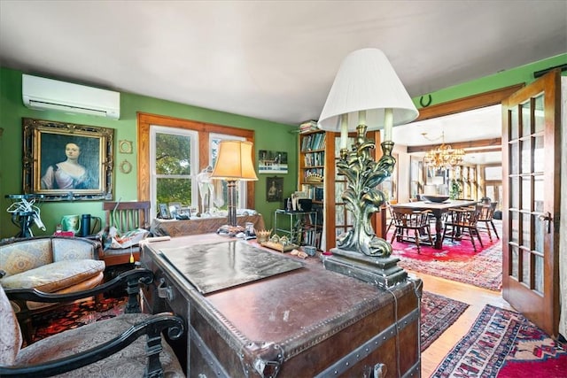 office with an AC wall unit, french doors, wood-type flooring, and an inviting chandelier