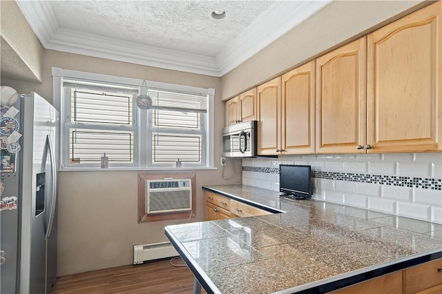 kitchen with dark wood-type flooring, a baseboard heating unit, crown molding, a textured ceiling, and stainless steel appliances