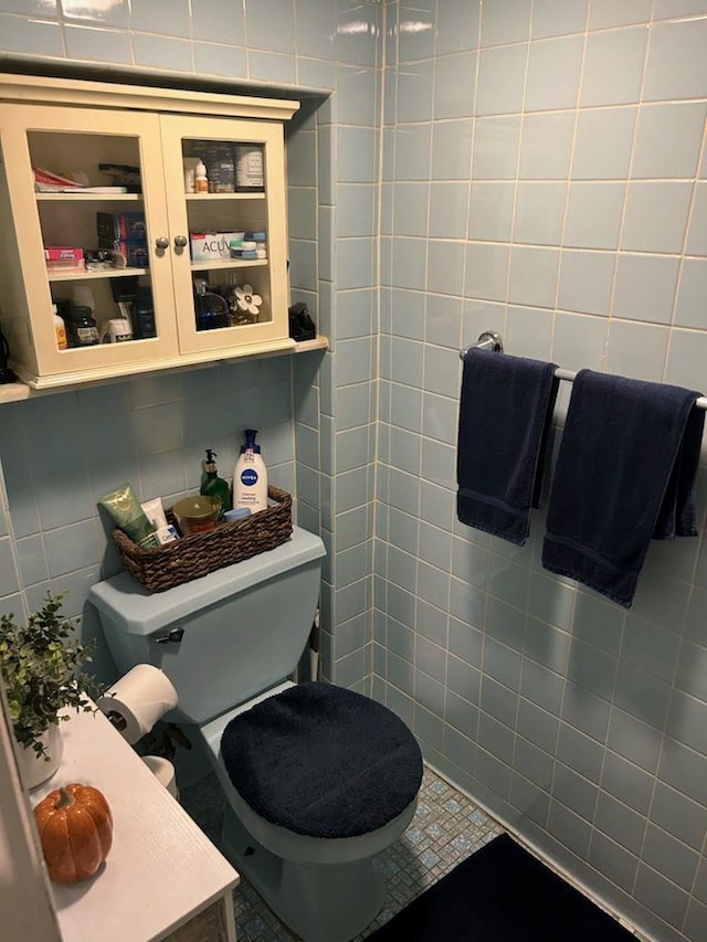 bathroom with toilet and tile walls