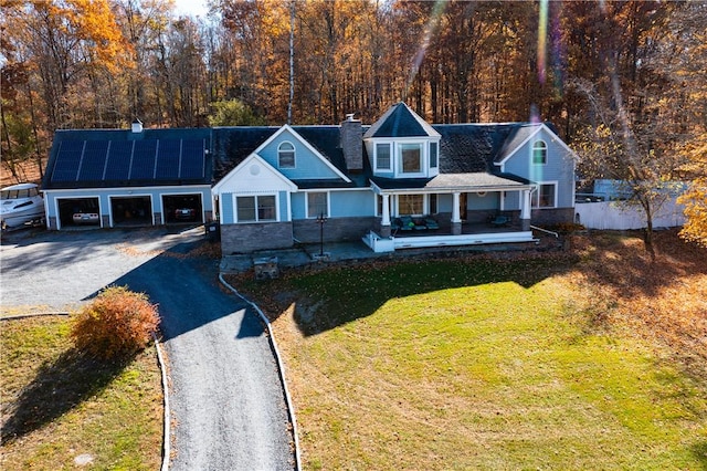 view of front of property with a front yard, solar panels, and a porch